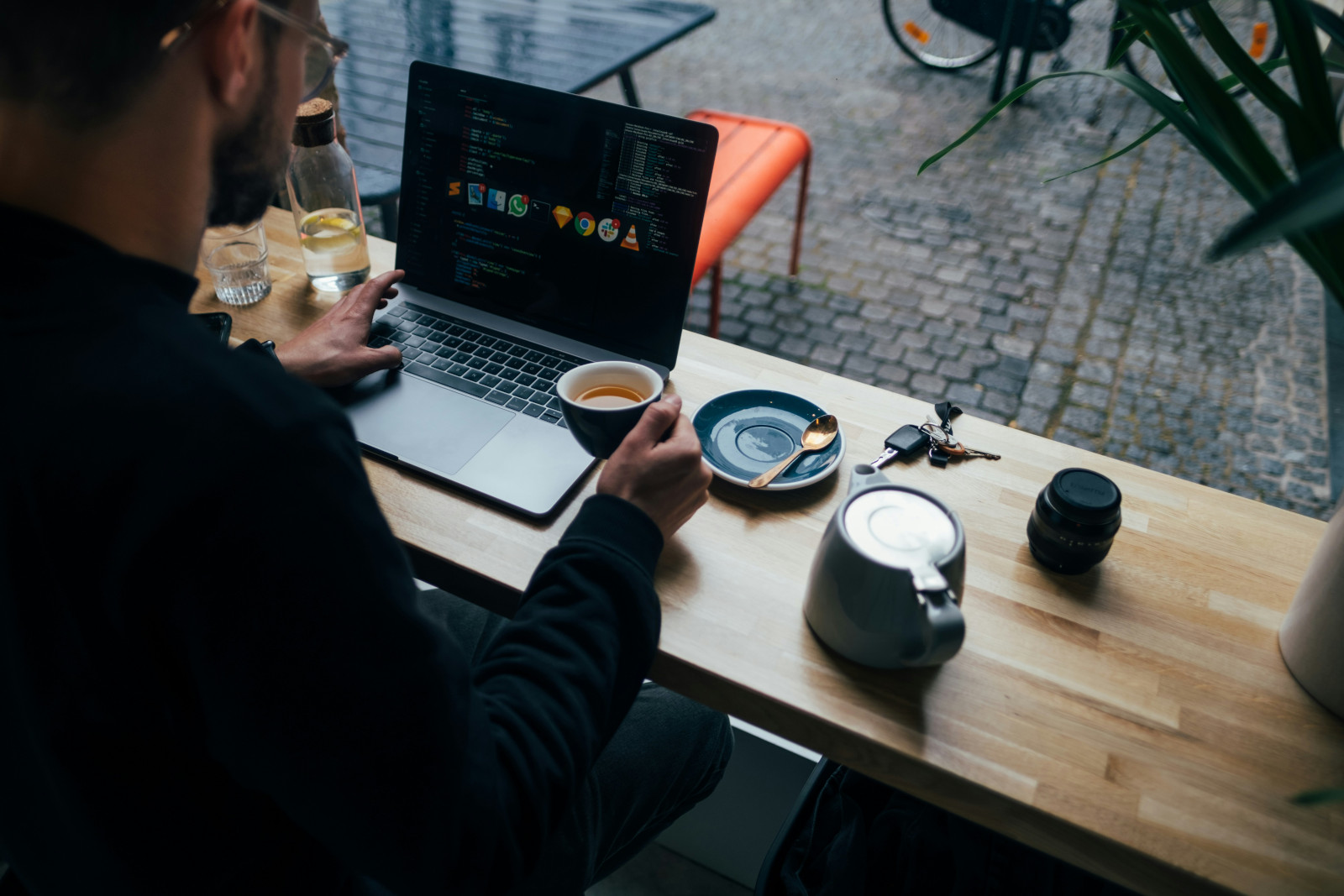 Image of an administrative assistant multitasking administrative tasks on his laptop while drinking a coffee.