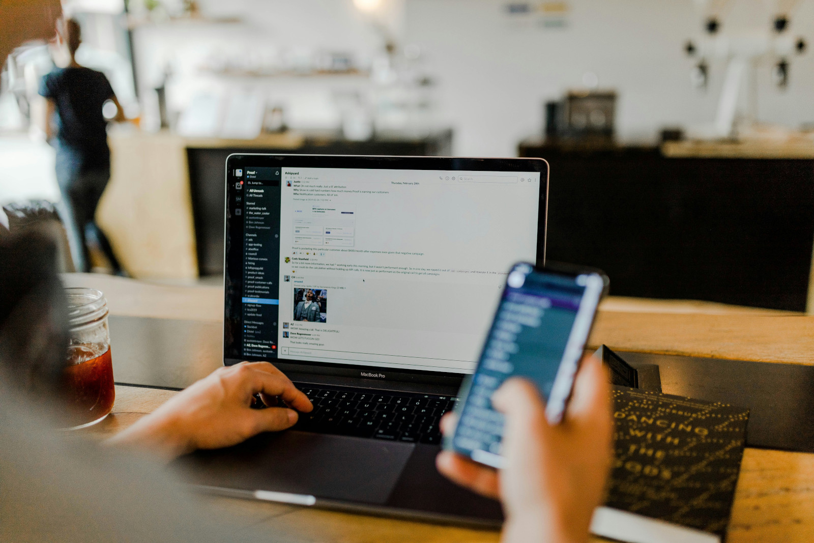 Administrative professional using slack on laptop and another tool on iphone